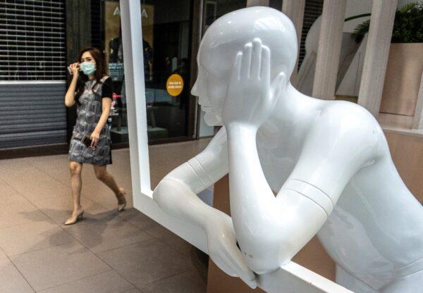 A woman wearing a mask enters a shopping mall, partially closed to combat the spread of the CCP virus, in Bangkok on April 7, 2020. (Mladen Antonov /AFP via Getty Images)