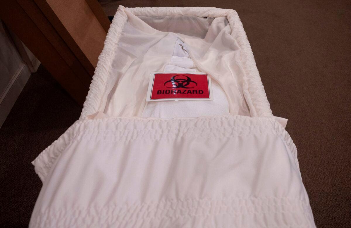 A biohazard sign on the body of a COVID-19 victim in a casket at the Stauffer Funeral Homes in Frederick, Maryland, on May 1, 2020. (Andrew Caballero-Reynolds/AFP via Getty Images)