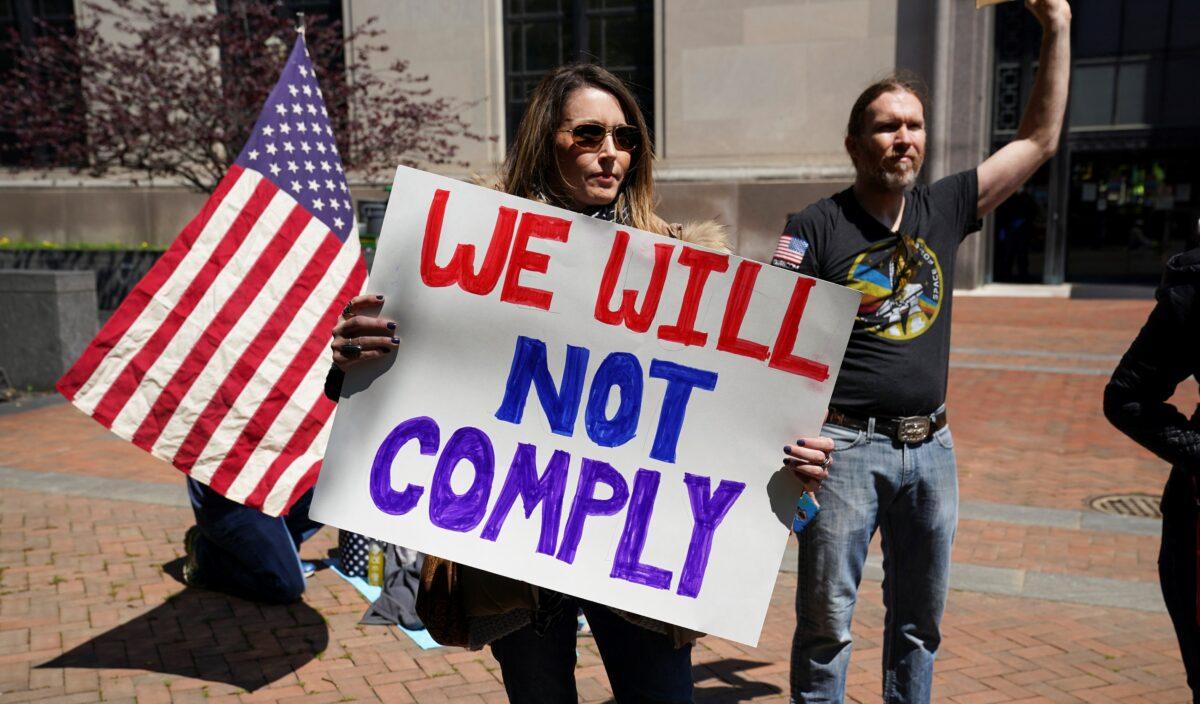 A protestor carries a sign reading "We Will Not Comply" during a demonstration outside the Virginia State Capitol to protest Virginia's stay-at-home order and business closures in the wake of the CCP virus outbreak in Richmond, Virginia on April 16, 2020. (Kevin Lamarque/Reuters)