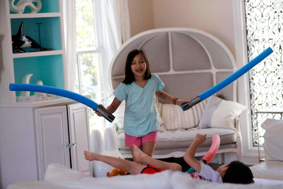 Juliet Daly, 12, plays with her brother Dominic, 5, in their family home in Covington, La., on April 30, 2020. (Gerald Herbert/AP Photo)