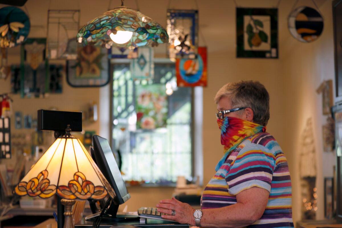 Vicki Driscoll works behind the counter at The Glass Workbench glass and gift shop in St. Charles, Mo. on May 4, 2020. (Jeff Roberson/AP Photo)