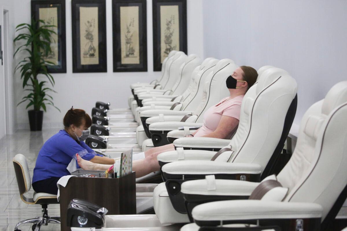 Shalee Williams (R) receives a pedicure at Lotus Nail Spa in Stansbury Park, Utah on May 4, 2020. Nail salons, gyms, and restaurants are among some Utah businesses that were allowed to open their doors under new guidelines. (Rick Bowmer/AP Photo)