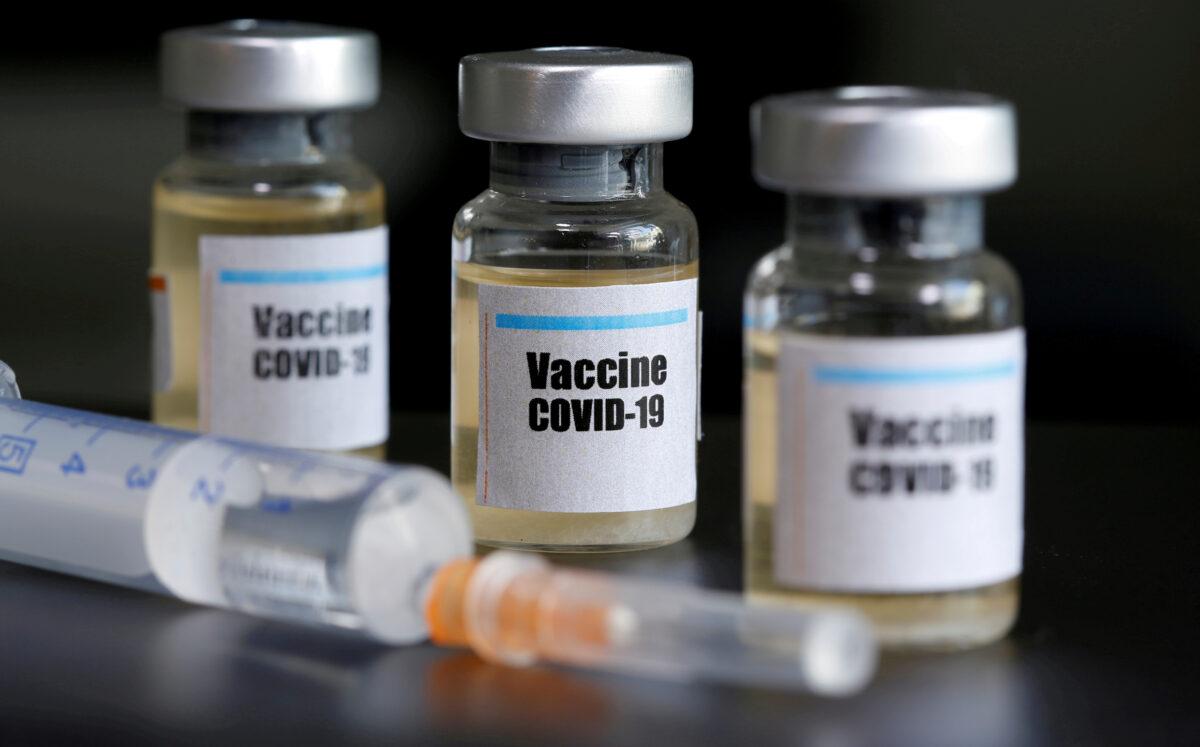 Small bottles labeled with a "Vaccine COVID-19" sticker and a medical syringe on April 10, 2020. (Dado Ruvic/Illustration/Reuters)
