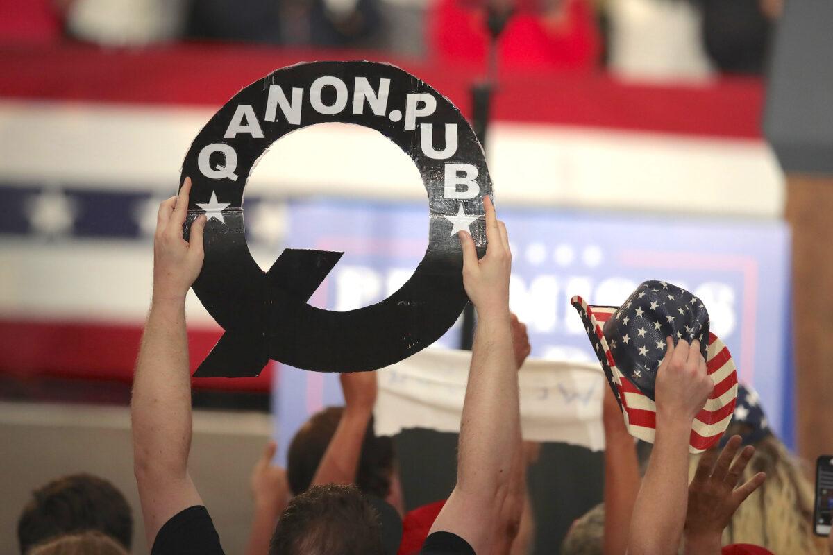 A rallygoer holds up a cutout of the letter Q, in Lewis Center, Ohio, on Aug. 4, 2018. (Scott Olson/Getty Images)