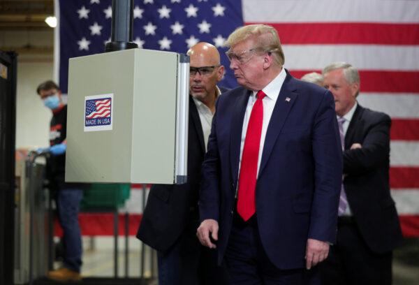 President Donald Trump looks at an assembly line machine manufacturing protective masks being shown to him by Honeywell's Vice President of Integrated Supply Chain Tony Stallings in Phoenix, Arizona, on May 5, 2020. (Tom Brenner/Reuters)