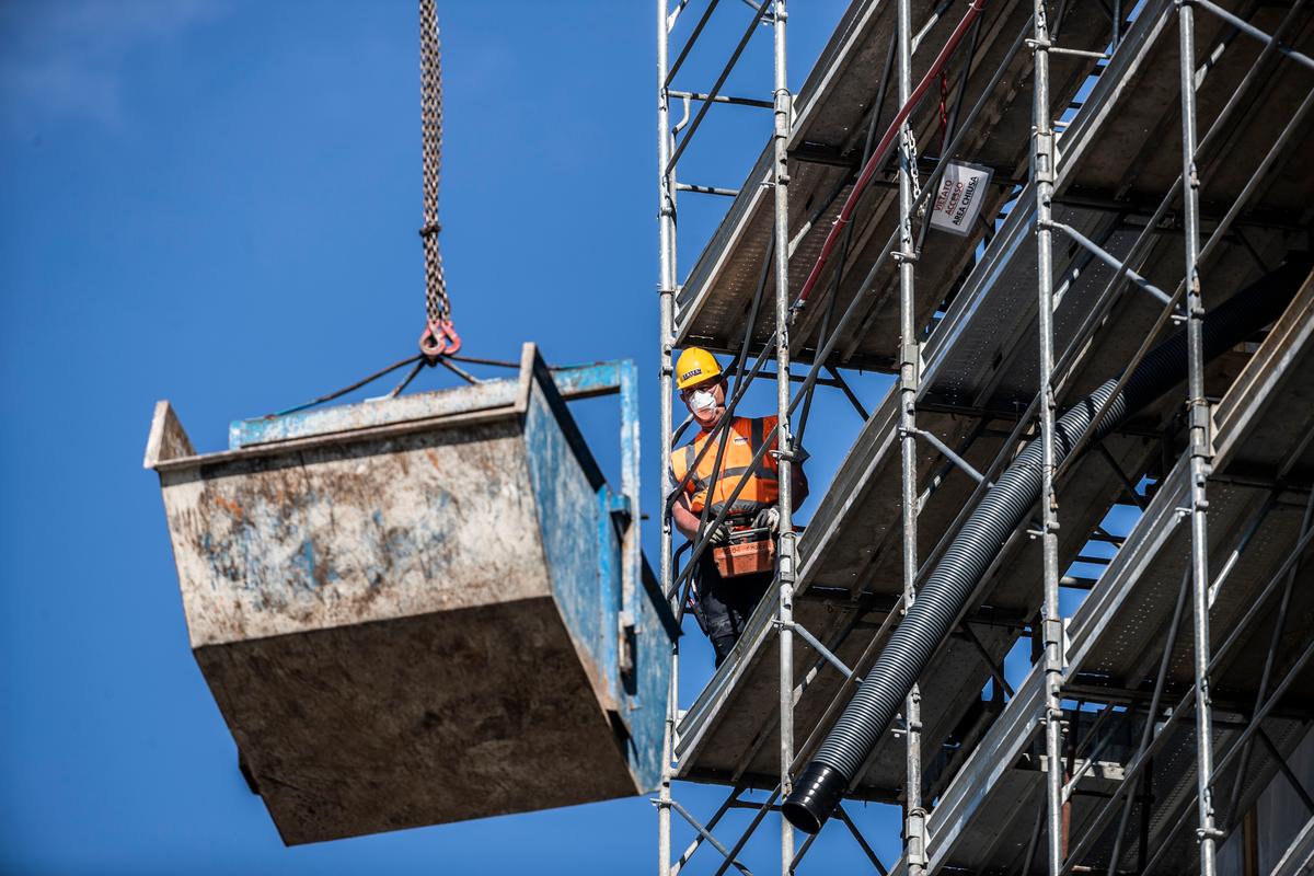 A worker operates at a construction site in Milan, Italy, Thurs., May 7, 2020. (AP Photo/Luca Bruno)