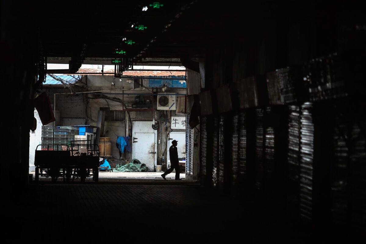An employee walks past the closed Huanan Seafood Wholesale Market, which has been linked to cases of CCP virus, in Wuhan, Hubei province, China, on Jan. 17, 2020. (Getty Images)