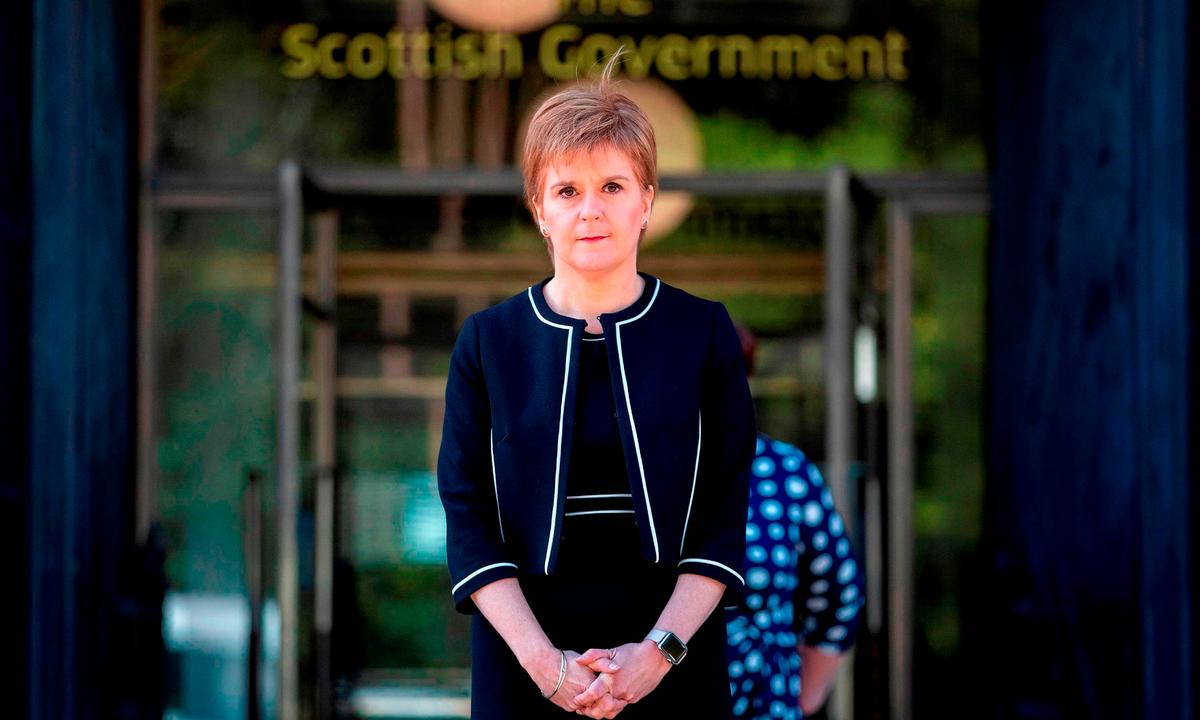Scotland's First Minister Nicola Sturgeon pauses for a minute's silence to honor UK key workers, including Britain's NHS (National Health Service) staff, health, and social care workers, who have died during the CCP virus outbreak, outside At Andrew's House in Edinburgh on April 28, 2020. (Jane Barlow/POOL/AFP/ Getty Images)