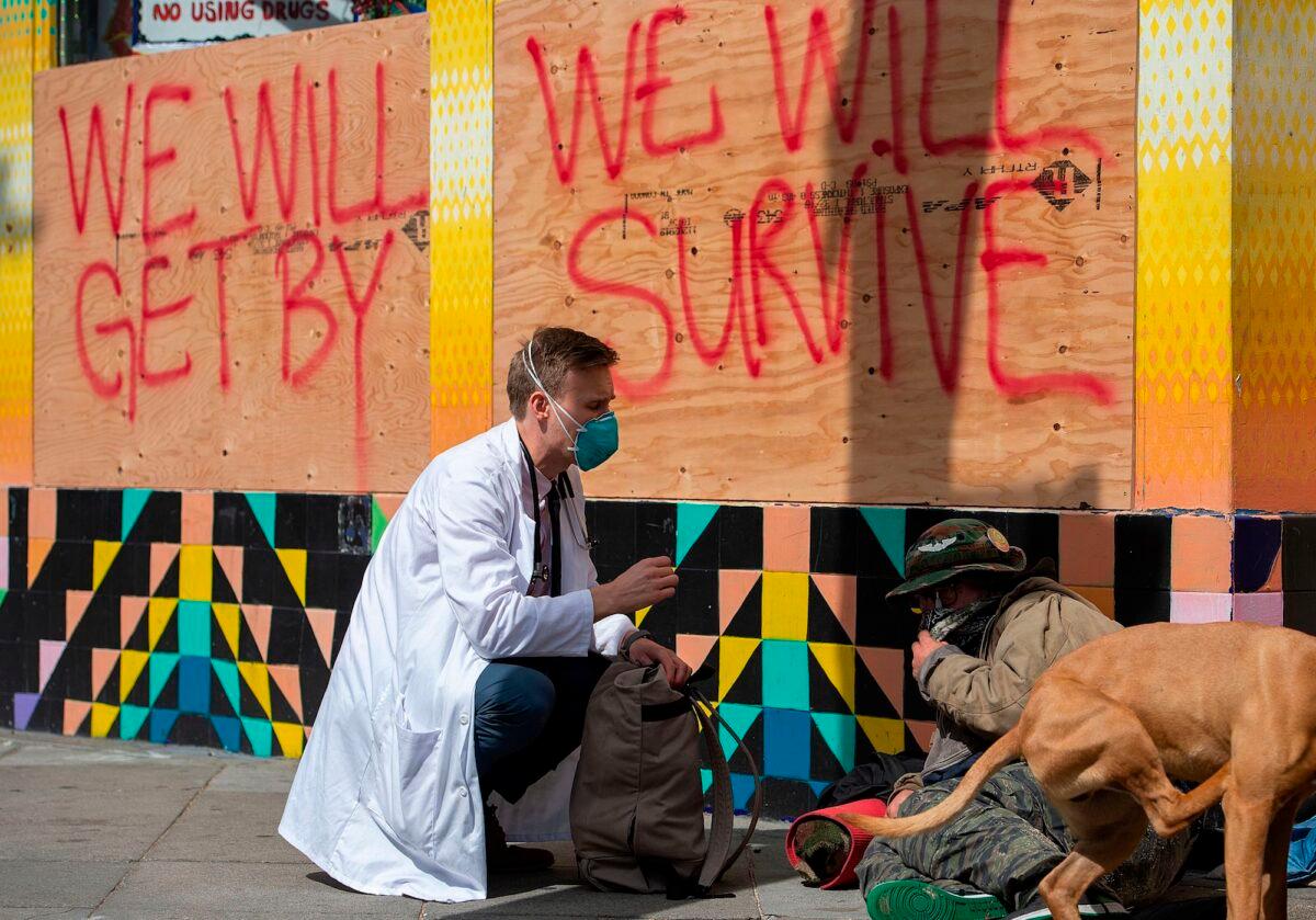 Stuart Malcolm, a doctor with the Haight Ashbury Free Clinic, speaks with homeless people about COVID-19, in San Francisco, Cali., on March 17, 2020. (Josh Edelson/AFP/Getty Images)