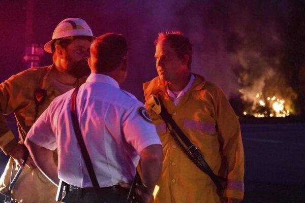 South Walton Fire Chief Ryan Crawford, right, speaks to Walton County Fire Rescue EMS Chief Tracey Vause, foreground, and an unidentified firefighter as they respond to a fire at Santa Rosa Beach near Highway 98 in Walton County, Fla., on May 6, 2020. (Walton County Sheriff's Office via AP)