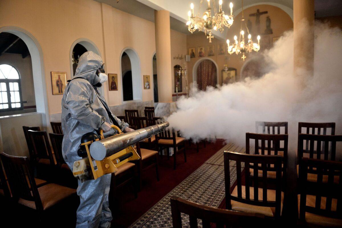 A worker uses a thermal fogger to disinfect a church in Thessaloniki, Greece, on March 12, 2020. (Sakis Mitrolidis/AFP/Getty Images)