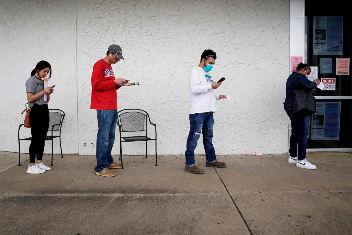 People who lost their jobs wait in line to file for unemployment at an Arkansas Workforce Center in Fayetteville, Ark., on April 6, 2020. (Reuters/Nick Oxford)