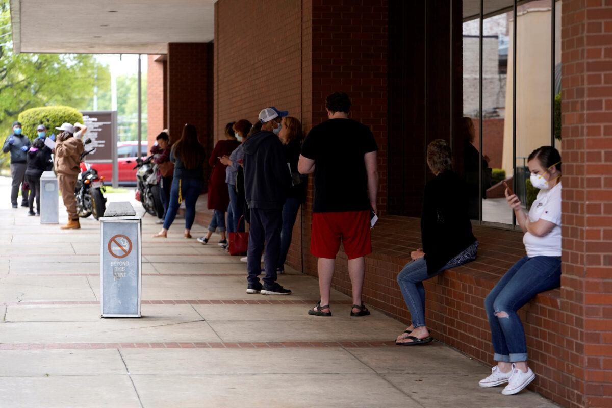 People who lost their jobs wait in line to file for unemployment at an Arkansas Workforce Center in Fayetteville, Ark., on April 6, 2020. (Nick Oxford/Reuters)