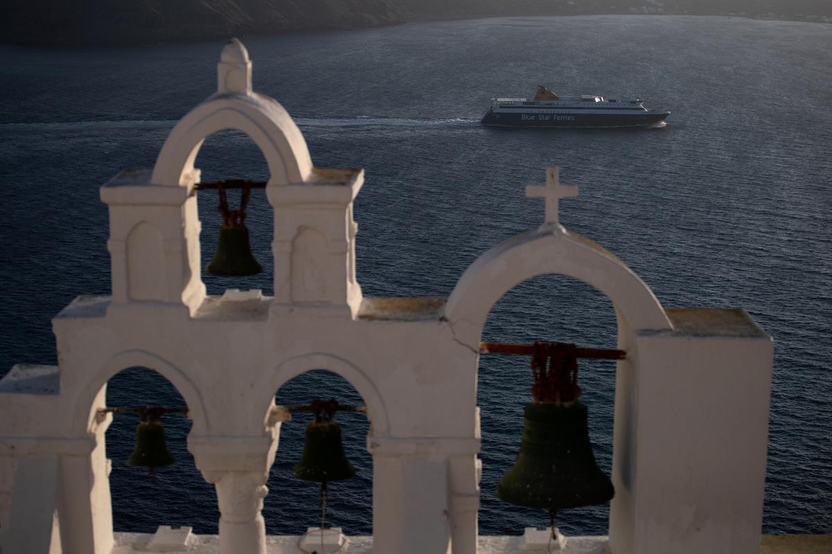 A ferry sails next to the caldera of Oia, Santorini, Greece, May 6, 2020. (REUTERS/Alkis Konstantinidis)