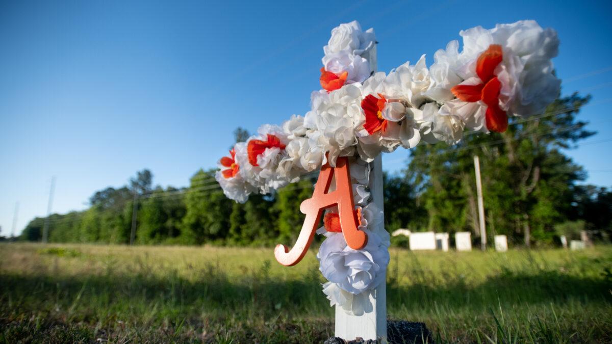 A cross with flowers and a letter A sits at the entrance to the Satilla Shores neighborhood where Ahmaud Arbery was shot and killed in Brunswick, Ga., on May 7, 2020. (Sean Rayford/Getty Images)
