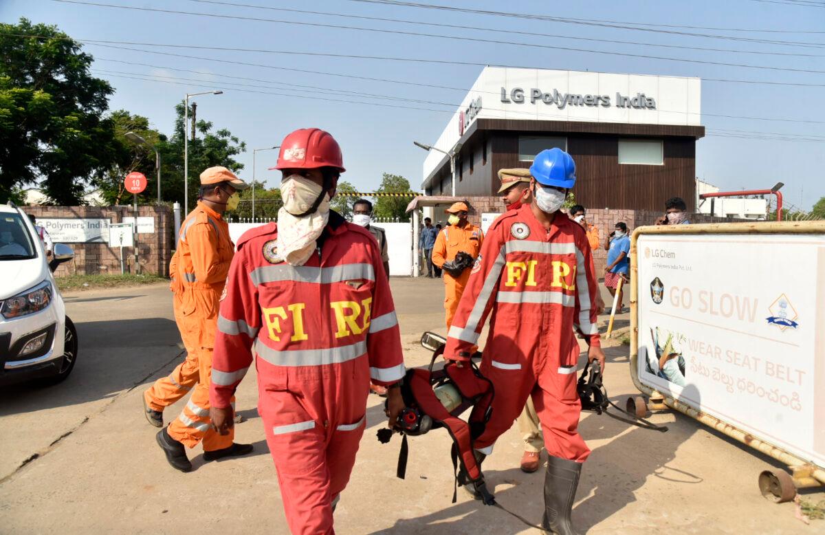Firefighters walk with oxygen cylinders outside LG Polymers plant, the site of a chemical gas leak, in Vishakhapatnam, India, on May 7, 2020. (AP Photo)