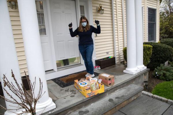 Elementary school teacher Luciana Lira celebrates a delivery of home-cooked meals for her family from a school cafeteria worker, in Stamford, Connecticut, on May 1, 2020. (Photo by John Moore/Getty Images)