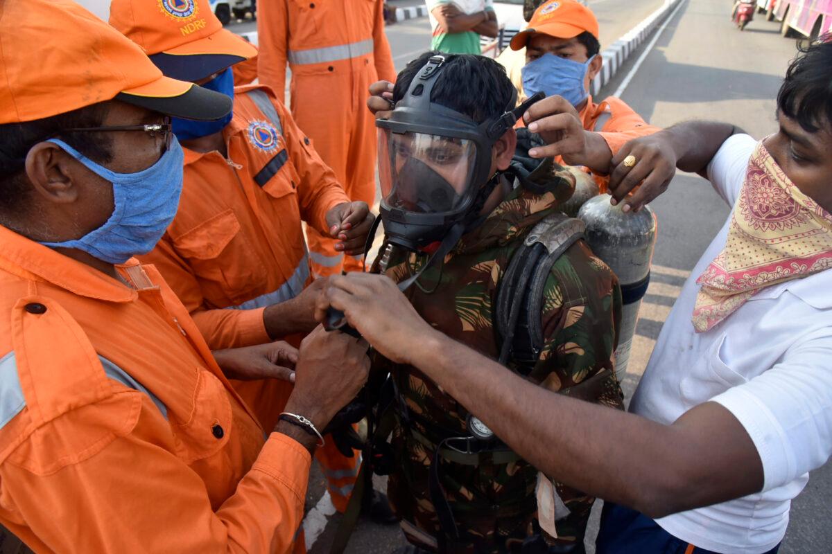 A National Disaster Response Force (NDRF) soldier is fitted with gear before he proceeds to the area from where chemical gas leaked in Vishakhapatnam, India, on May 7, 2020. (AP Photo)