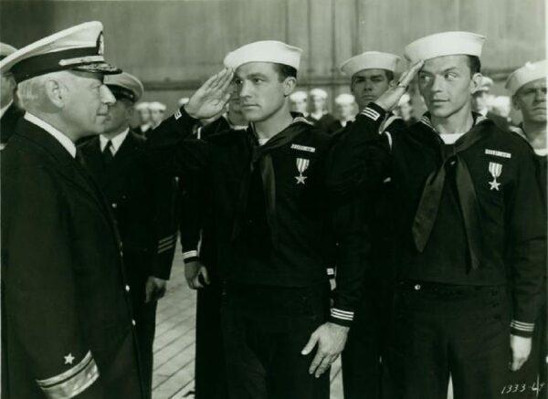 (L–R, front) Adm. Hammond (Henry O'Neill) commends and gives a four-day pass to sailors Joe Brady (Gene Kelly) and Clarence Doolittle (Frank Sinatra) in “Anchors Aweigh.” (MGM)