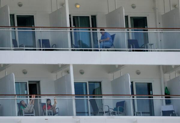 People aboard the Norwegian Epic cruise ship docked in Miami, sit on their balconies on May 8, 2020. (Wilfredo Lee/AP photo)