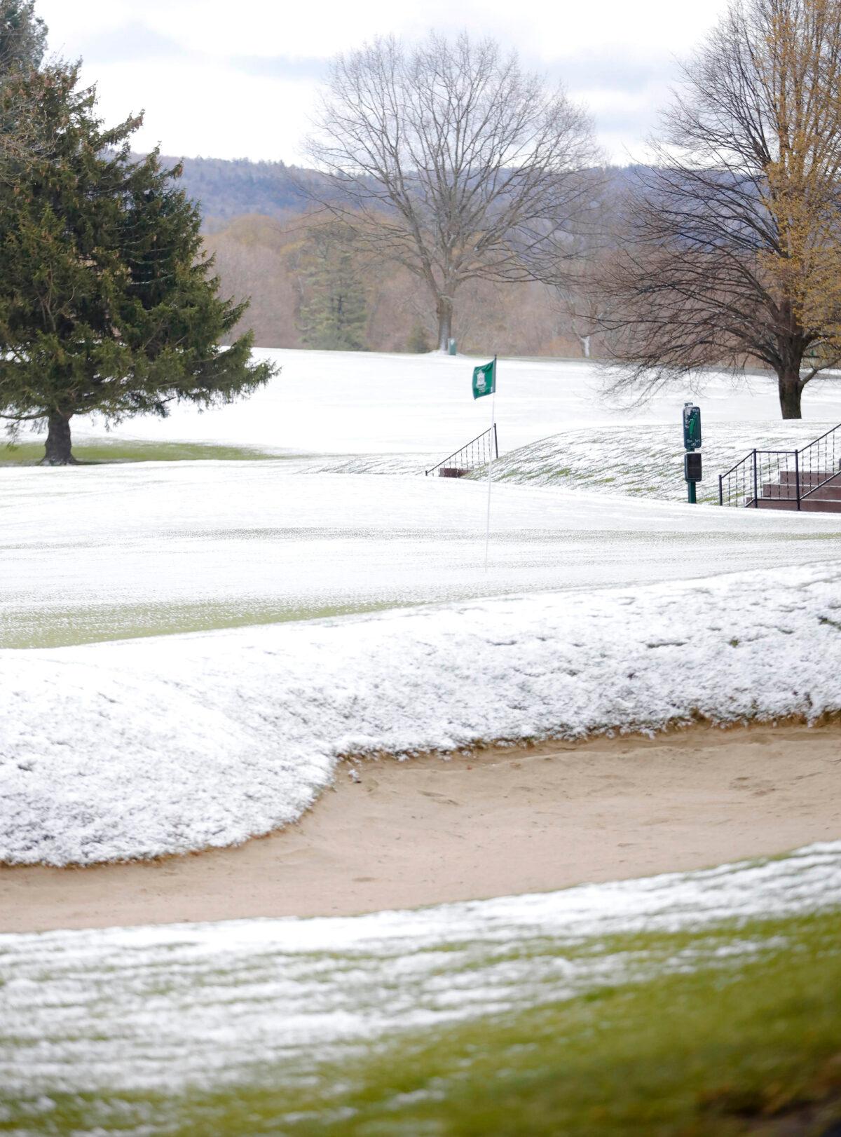 The greens and fairways are covered in snow, just as golf courses were starting to open for the season at Country Club of Pittsfield, Mass., on May 9, 2020. (Stephanie Zollshan/The Berkshire Eagle via AP)