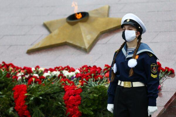 Amid the CCP virus pandemic, a Russian cadet wearing a mask stands guard in front of a military memorial during a ceremony to mark the 75th anniversary of the victory over Nazi Germany in World War Two in Vladivostok, Russia, on May 9, 2020. (Pavel Korolyov/AFP via Getty Images)