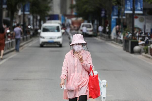 A woman walks along a street in Wuhan, China on May 11, 2020. (STR/AFP via Getty Images)