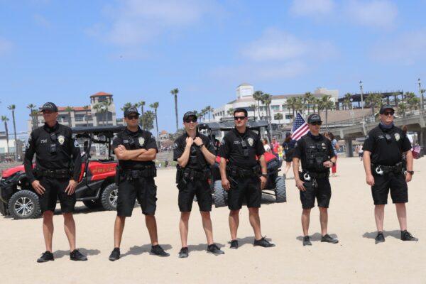 Police keep watch over protests in Huntington Beach, Calif., on May 9, 2020. (Jamie Joseph/The Epoch Times)