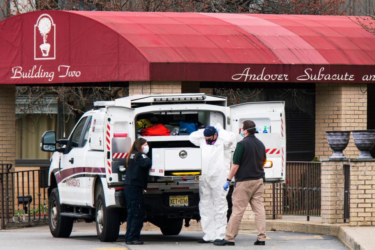 Medical workers put on masks and personal protective equipment (PPE) while preparing to transport a deceased body at Andover Subacute and Rehabilitation Center in Andover, N.J. on April 16, 2020. (Eduardo Munoz Alvarez/Getty Images)
