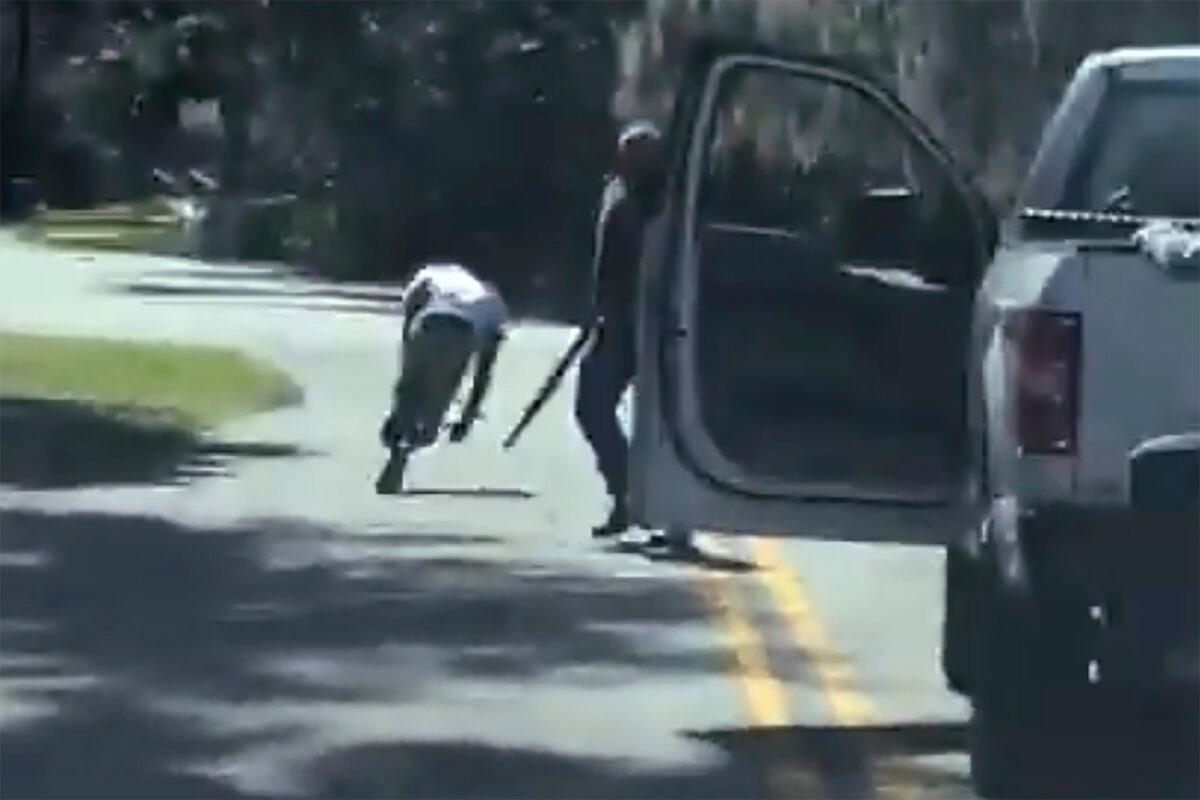 This image from video posted on Twitter Tues., May 5, 2020, purports to show Ahmaud Arbery stumbling and falling to the ground after being shot as Travis McMichael stands by holding a shotgun in a neighborhood outside Brunswick, Ga., on Feb. 23, 2020. The AP has not been able to verify the source of the video. (Twitter via AP)