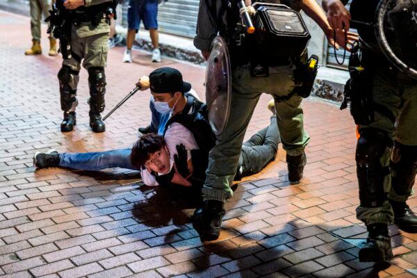 A pro-democracy demonstrator (C) is held on the ground before getting arrested by undercover police during a protest calling for the city's independence in Mong Kok district of Hong Kong on May 10, 2020. (Isaac Lawrence/AFP via Getty Images)