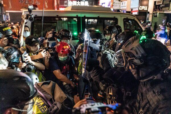 Riot police hold back members of media during a demonstration in Mongkok district in Hong Kong, on May 10, 2020. (Anthony Kwan/Getty Images)