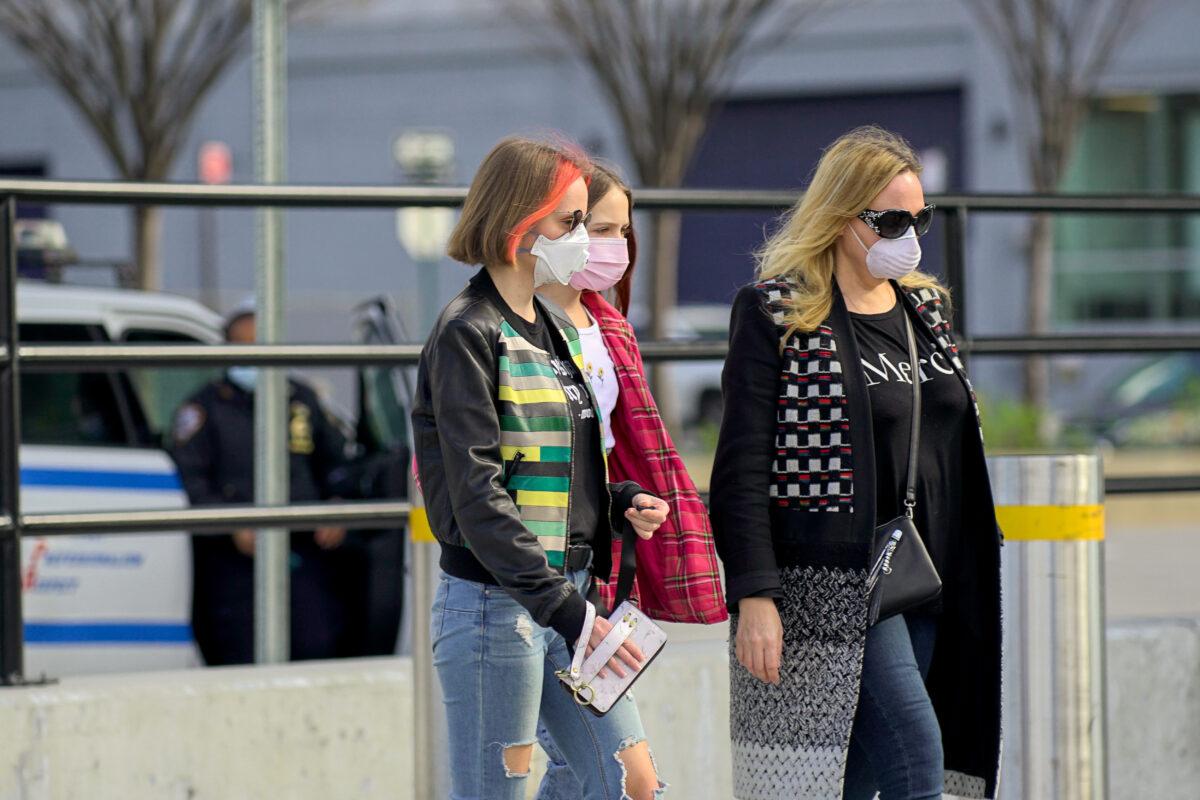 People wear masks as they walk on the street in New York City on April 4, 2020. (Chung I Ho/The Epoch Times)