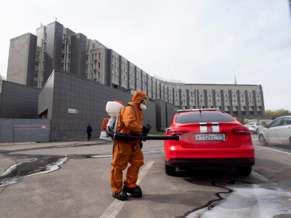A Russian Emergency Situation worker disinfects a fire department car near the scene of a fire at St. George Hospital in St. Petersburg, Russia, on May 12, 2020. (Dmitry Lovetsky/AP Photo)