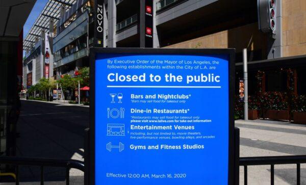 A sign in place since mid-March announces the temporary closures of restaurants, nightclubs, gyms, and entertainment venues at LA Live in Los Angeles on May 7, 2020. (Frederic J. Brown/AFP via Getty Images)