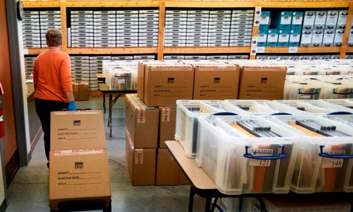 Nadette Cheney wheels in boxes of printed ballots into the storage room of the Lancaster County Election Committee offices in Lincoln, Neb., on April 14, 2020. (Nati Harnik/AP Photo)