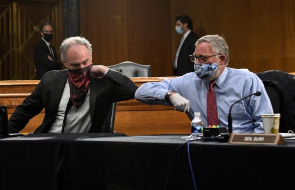 Sens. Tim Kaine (D-Va.) and Richard Burr (R-N.C.) greet each other with an elbow bump before the Senate Committee for Health, Education, Labor, and Pensions hearing on COVID-19, in Washington on May 12, 2020. (Toni L. Sandys/Pool/Reuters)