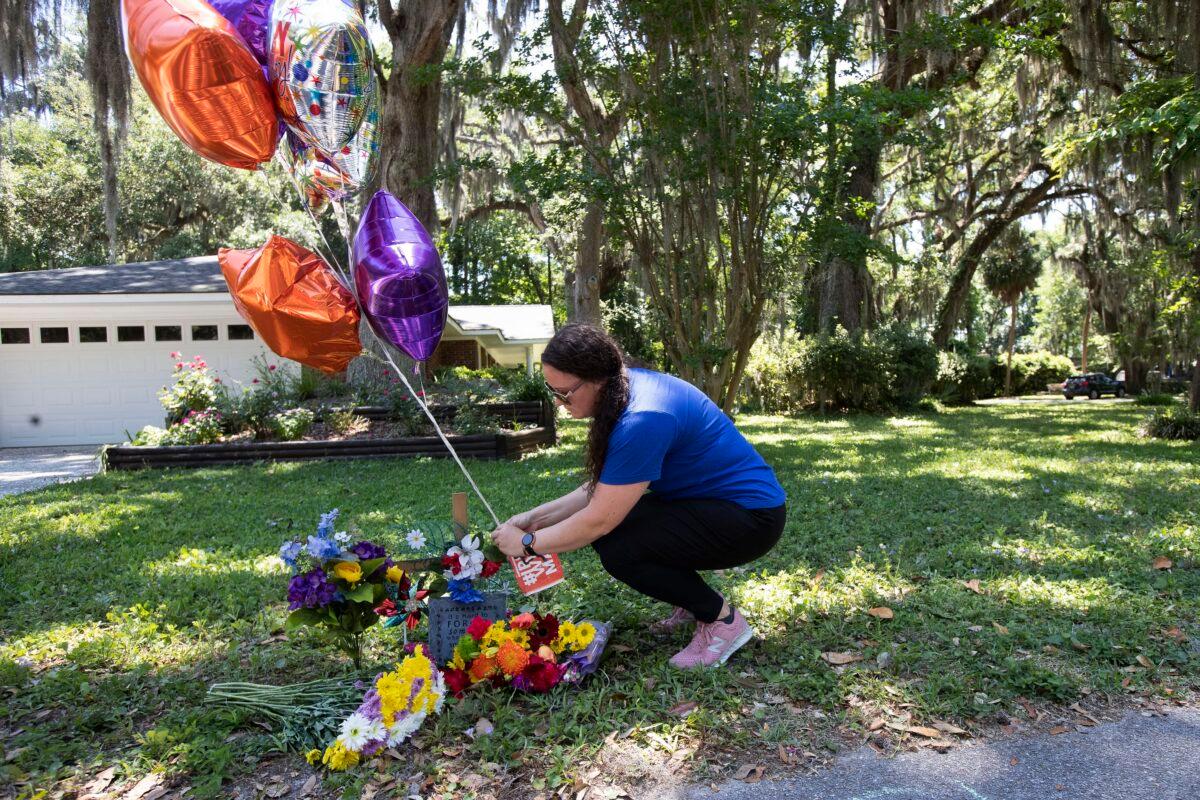Erica Smith, of Brunswick, Ga., leaves a small paper sign on a memorial at the spot where Ahmaud Arbery was shot and killed Fri., May 8, 2020, in Brunswick Ga. Two men have been charged with murder in the February shooting death of Arbery, a black man in his mid-20s, whom they had pursued in a truck after spotting him running in their neighborhood. (John Bazemore/AP Photo)