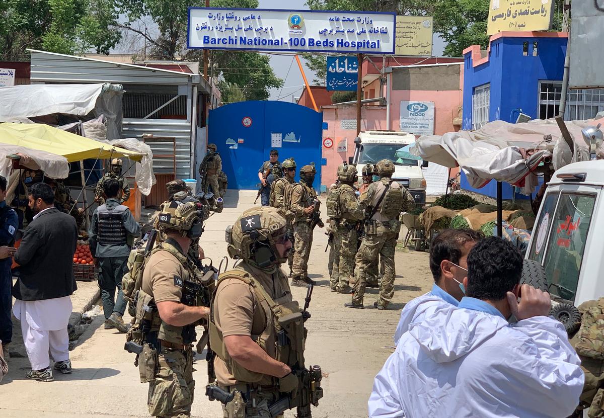 Afghan and foreign security personnel stand guard in front of a hospital after gunmen attacked, in Kabul, Afghanistan, on May 12, 2020. (Rahmat Gul/AP Photo)