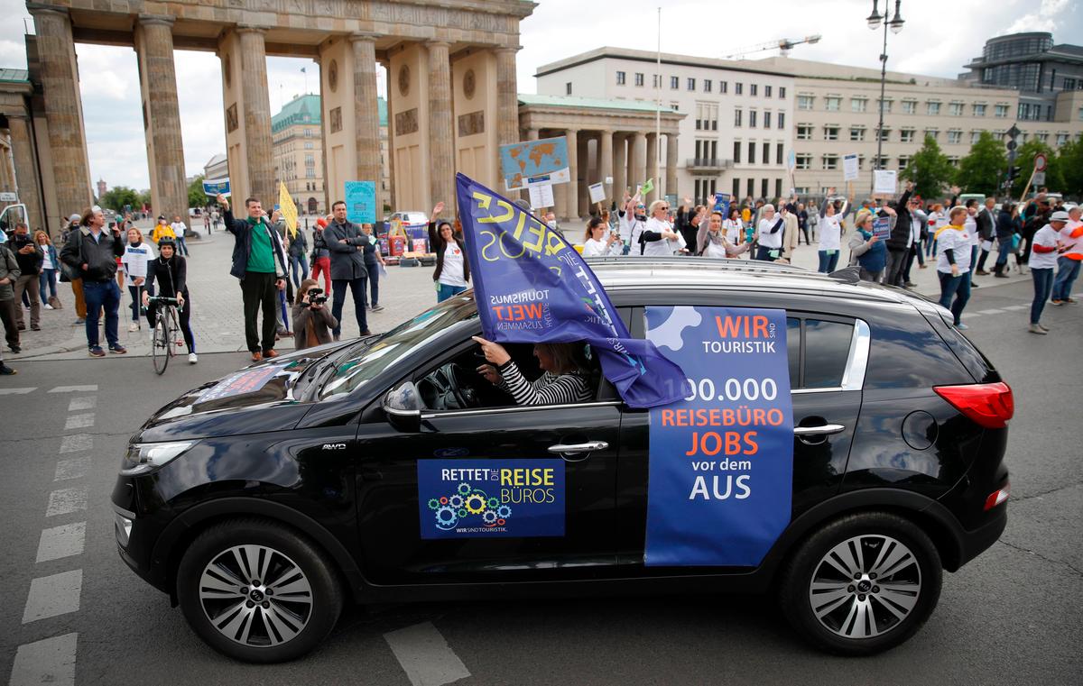 Travel agency workers demonstrate close to Berlin's landmark the Brandenburg Gate in order to point to the economic plight of the touristic sector, claiming for rescue packages to save jobs amid the CCP virus pandemic, Berlin, Germany, on May 13, 2020. (Odd Andersen/ AFP via Getty Images)