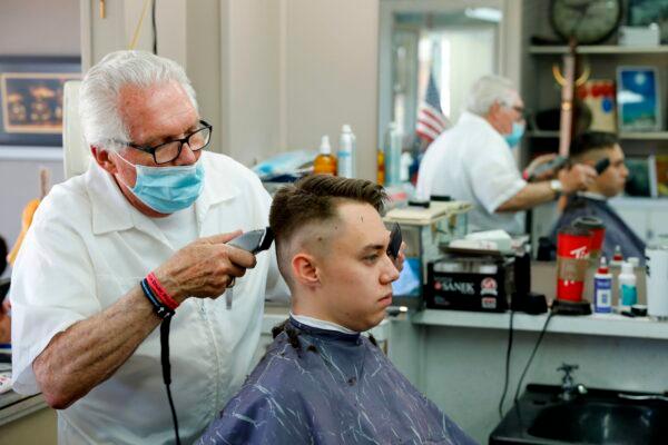 Barber Karl Manke cuts a client's hair at his barbershop in Owosso, Mich., on May 12, 2020. (Jeff Kowalsky/AFP/Getty Images)