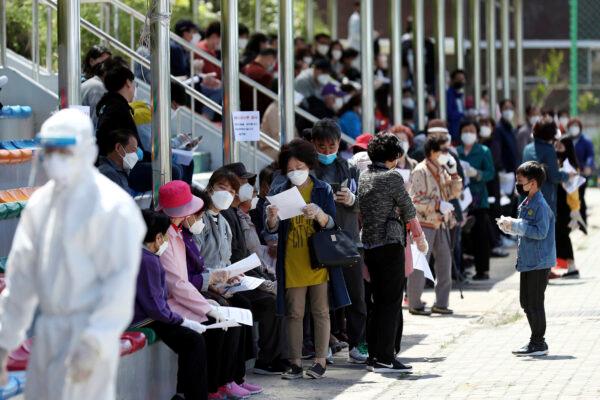People wearing face masks wait to take a test for the CCP virus at a testing facility in Incheon, South Korea, on May 13, 2020. (Yun Tae-hyun/Yonhap/AP)