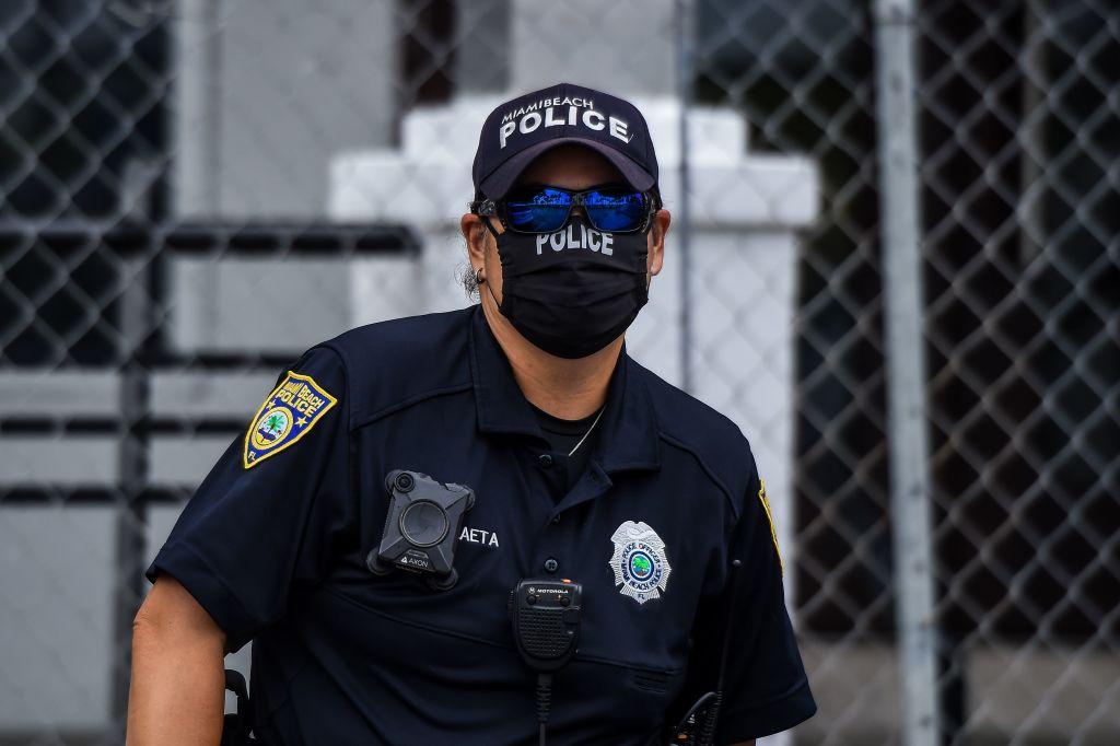 A police officer wears a mask amid fears over the spread of the novel coronavirus (COVID-19) while standing guard at a "Freedom Rally" protest in support of opening Florida in South Beach in Miami, on May 10, 2020. (Chandan Khanna/AFP)