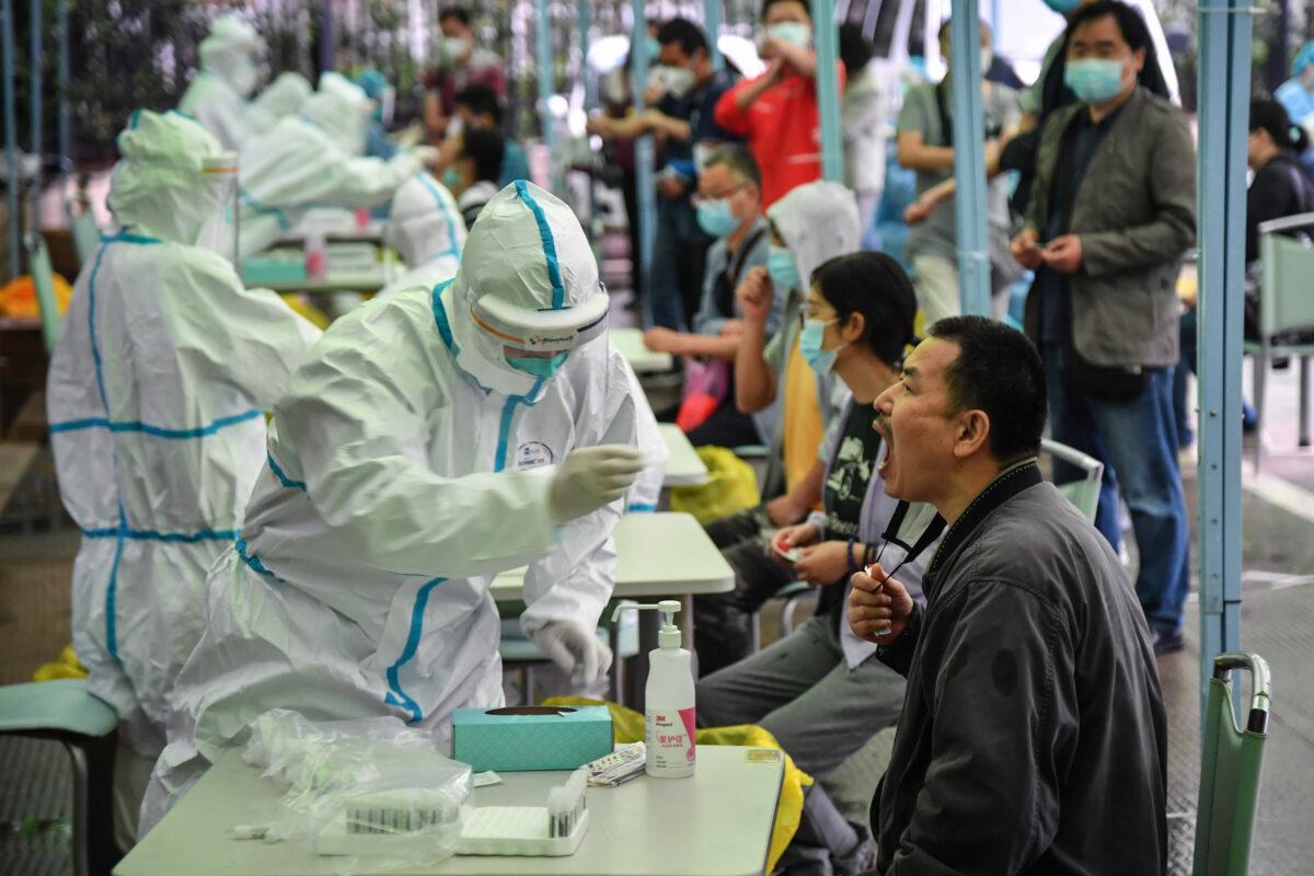 A medical worker takes a swab sample from a resident to be tested for COVID-19 in Wuhan, China, on May 14, 2020. (STR/AFP via Getty Images)