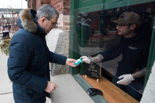 A customer buys s hand sanitizers at Spirit of York distillery in Toronto, Ontario, on March 19, 2020. (Lars Hagberg / AFP via Getty Images)