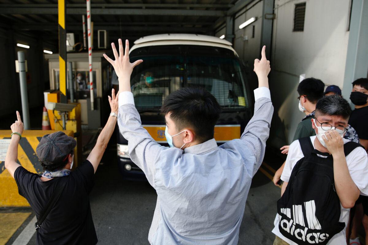 Supporters raise their hands up symbolizing of the "Five demands, not one less" to bid farewell to a prison van after protester Sin Ka-ho has been sentenced four years for rioting, in Hong Kong, China on May 15, 2020. (Tyrone Siu/Reuters)