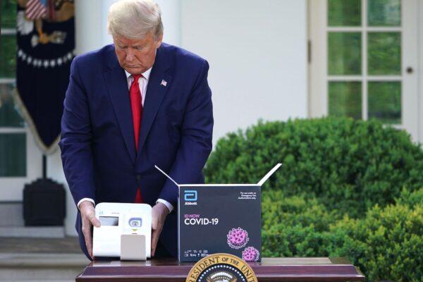 President Donald Trump holds a test for COVID-19 from Abbott Laboratories in the Rose Garden of the White House in Washington, on March 30, 2020. (Mandel Ngan/AFP via Getty Images)