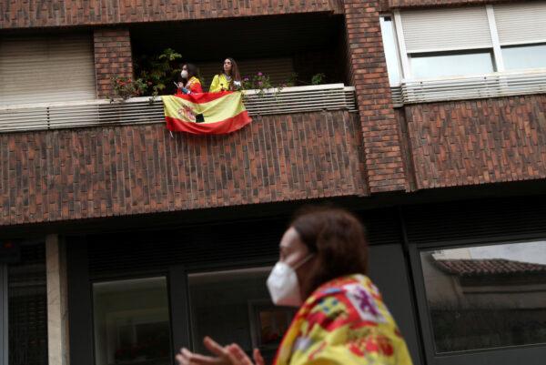Women stand on a balcony during a protest against the Spanish government's handling of the CCP virus (COVID-19) crisis, in Madrid, Spain, on May 15, 2020. (Susana Vera/Reuters)