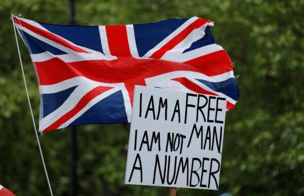 An anti lockdown protester holds up a banner and union jack flag in Hyde Park, following the outbreak of COVID-19, London, Britain, on May 16, 2020. (John Sibley/Reuters)
