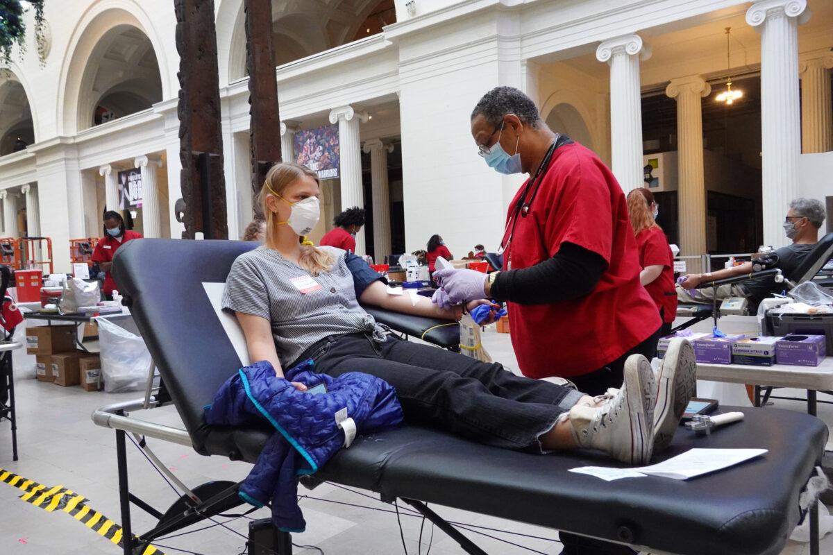 Phlebotomist Herbert Collins draws blood from Victoria Reese during an American Red Cross blood drive held at the Field Museum of Natural History in Chicago, Ill., on May 11, 2020. (Scott Olson/Getty Images)